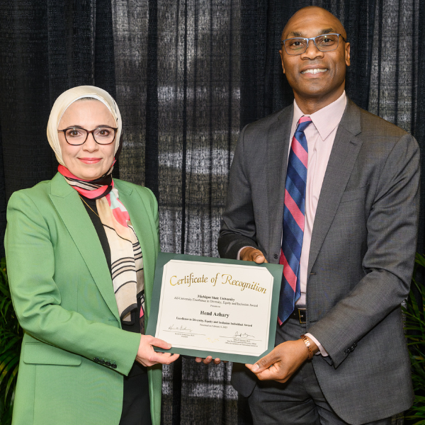 Hend Azhary, MD, assistant professor in the Department of Family Medicine, receiving the Individual Award.Posed with Jabbar Bennett, MSU's vice president and chief diversity officer.